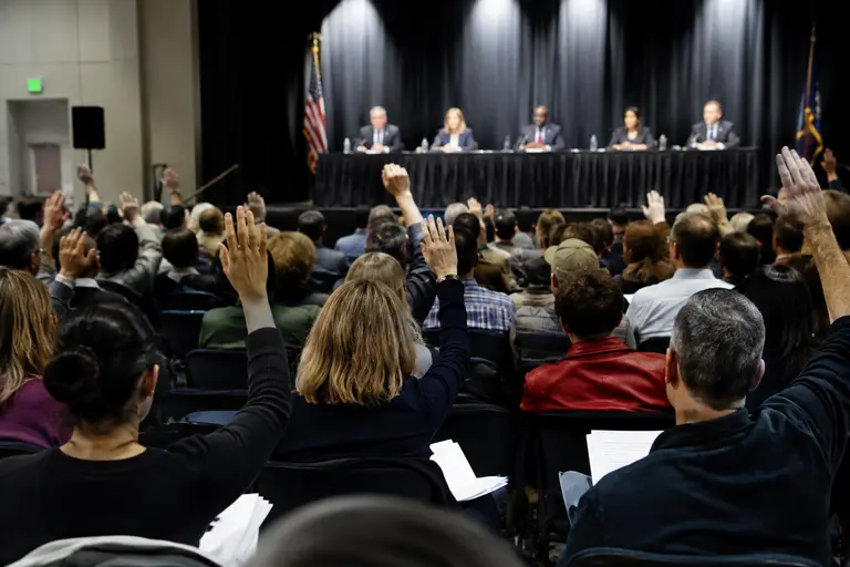 Community members seated at a public school board meeting
